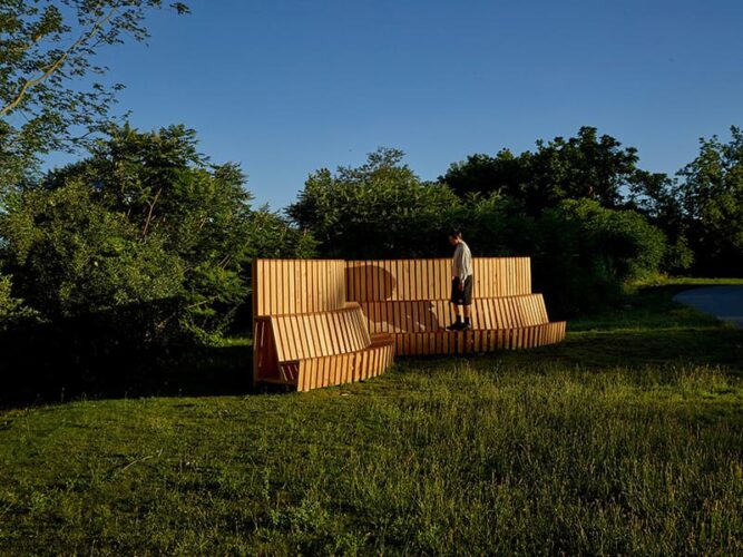 Person standing on a wooden abstract architectural installation